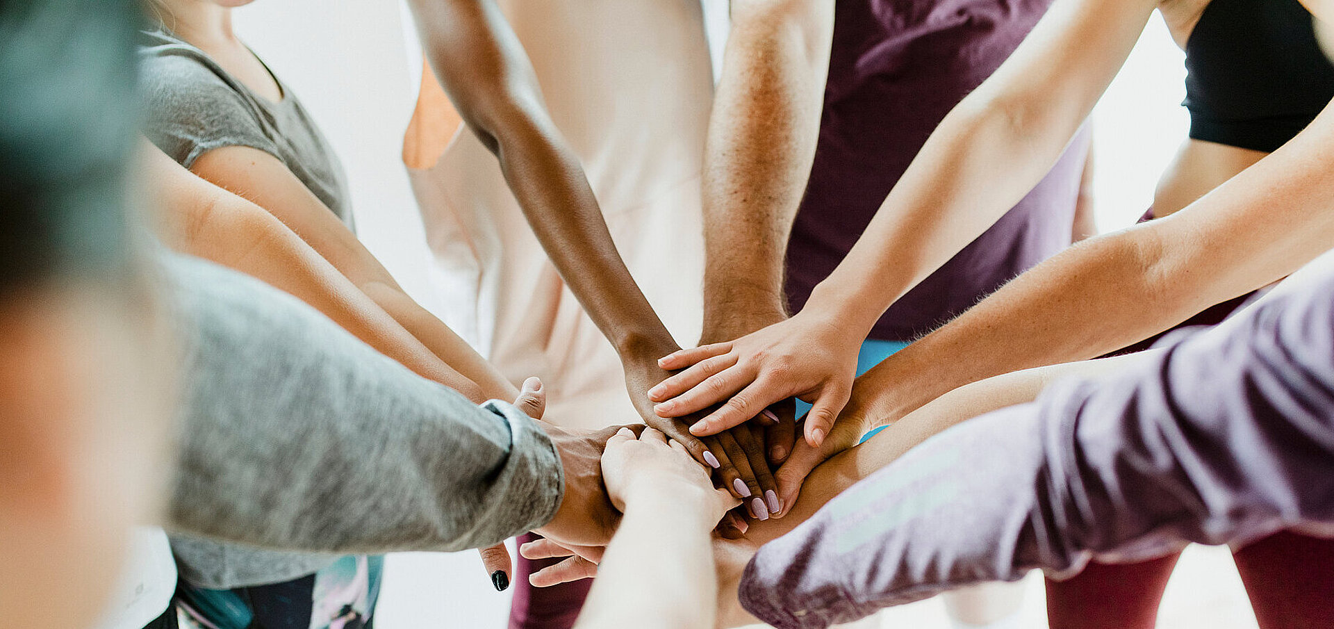 Gruppe von vielen Menschen strecken die Hände in der Mitte zusammen